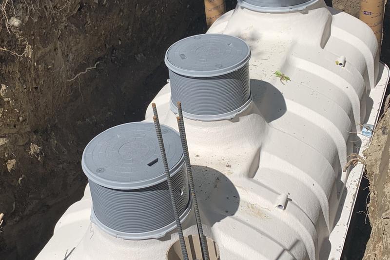 Tanques de tratamento compactos em polietileno instalados numa vala, com as tampas à superfície